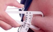 Fat calipers measuring the fat on a belly Fat calipers measuring the fat on a belly