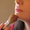 woman applying bronzer to chin