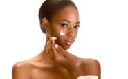 Afro-American girl putting on face cream Afro-American girl putting on face cream