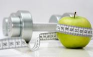 apple, measuring tape and chrome dumbbell