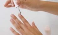 woman applying topical solution to nail fungus