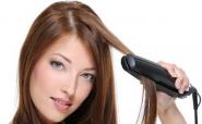 woman straightening hair with a flat iron